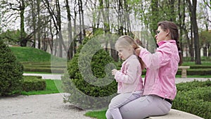 The nanny arranges the girl's hair and begins to braid it.