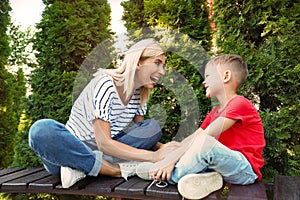 Nanny with cute little boy on bench