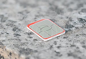 a nano SIM card for a mobile phone or smartphone lies on a stone surface