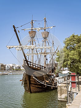 The Nao Victoria replica carrack ship docked at the Guadalquivir River in the historic central downtown area of Seville, Spain