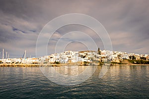 Naoussa coastal village Paros Island landscape view during golden hour with typical whitewashed cycladic houses, Greece