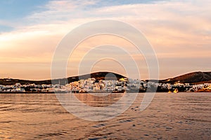 Naoussa coastal Village on Paros Island with white cycladic houses in pink sunrise colors, Greece.