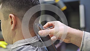 nape. hairdresser makes a haircut for a man with a hair clipper in a barbershop