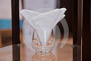 Napkin orderly manner fold in glass setting on dining table for dinner in luxury hotel
