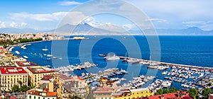 Naples city and port with Mount Vesuvius on the horizon seen from the hills of Posilipo. Seaside landscape of the city harbor and