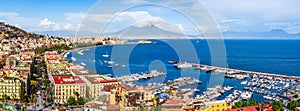 Naples city and port with Mount Vesuvius on the horizon seen from the hills of Posilipo. Seaside landscape of the city harbor and