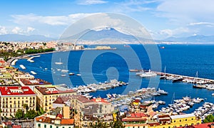 Naples city and port with Mount Vesuvius on the horizon seen from the hills of Posilipo. Seaside landscape of the city harbor and