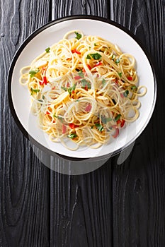 Naples traditional Aglio e Olio spaghetti close-up in a plate. Vertical top view