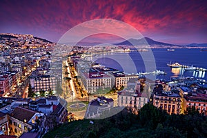 Naples, twilight evening pink violet sunset. Town Napoli in Italy, travelling in the Europe. Urban landscape with city, sea, hills