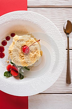 Napoleon cake serving on red and white background