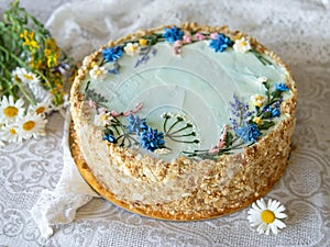 Napoleon cake with vanilla cream, decorated with buttercream flowers - summer wild flowers. Vintage style. Grey