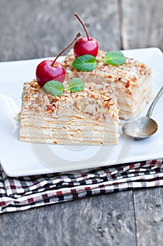 Napoleon cake with wild apple and mint on squared plate