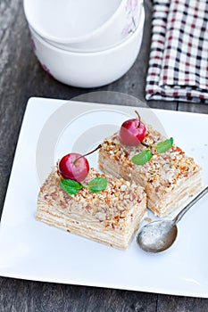 Napoleon cake with wild apples and mint on squared plate