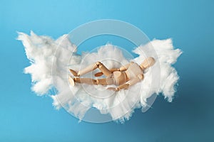 Napping toy man on comfortable cloud bed. Relax and dream