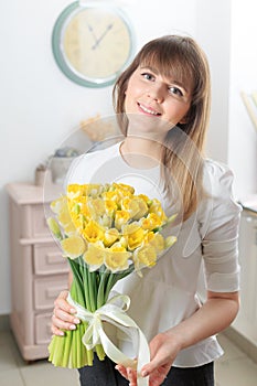 Narcissus beautiful flowers in womans hand. bouquet of delicate yellow color. the work of the florist at a flower shop.