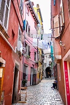 Narrow Alley With Street Life In The Old Town Of The City Of Rovinj In Croatia photo