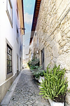 Narrow alley with irregular cobblestone floor and stone facades in a village called Valenca do Minho