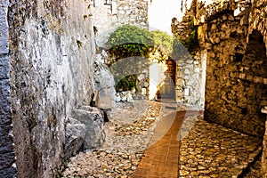 Narrow alley and old stone houses in Eze village in France