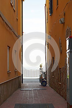 Narrow alley with a parked scooter in Giardini Naxos, Sicily, Italy