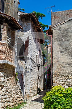 Narrow alley between two ruined old houses in the old town of Porec Parenzo, Croatia