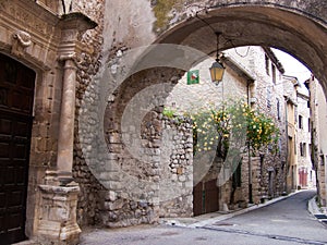 Narrow arched street surrounded by old residential buildings in Buis-les-Baronnies, France photo