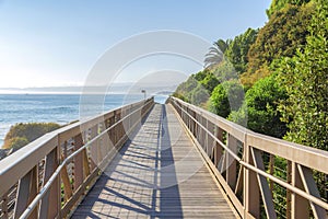 Narrow bridge near the mountain slope with green shrubs and railway in San Clemente, California