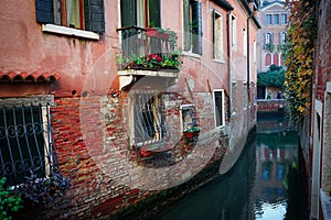 A narrow canal and colorful houses in Venice, Italy