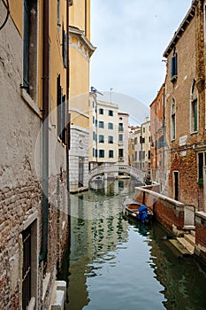 Narrow canal surrounded by old palaces in Venice photo