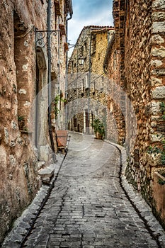 Narrow cobbled street with flowers in the old village France.