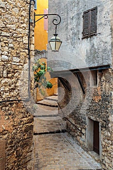 Narrow cobbled street with flowers in the old village Tourrettes-sur-Loup , France.