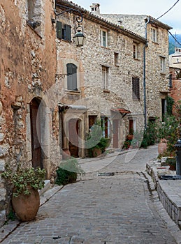 Narrow cobbled street with flowers in the old village Tourrettes-sur-Loup , France.