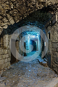 Narrow cobbled street in old town Peille at night, .