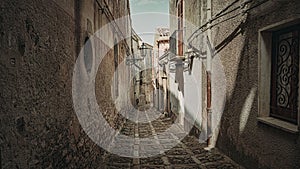 Narrow cobblestone alley in Erice, Sicily, Italy showcasing rustic architecture and vintage charm. photo