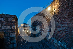 Narrow cobblestone path with an old fashioned lanterns inside Kalemegdan fortress at blue hour, Belgrade