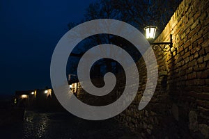 Narrow cobblestone path with an old fashioned lanterns inside Kalemegdan fortress at blue hour, Belgrade
