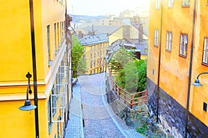 The narrow cobblestone street Bastugatan in Sodermalm with medieval houses in Stockholm at summer sunny day.