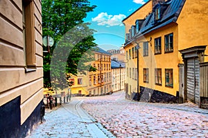 The narrow cobblestone street Bastugatan in Sodermalm with medieval houses in Stockholm at summer sunny day