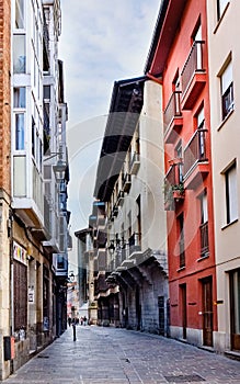 Narrow cobblestone street with facades of old houses with lots of color on the sides