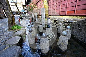 Narrow and cobblestoned Yanaka Lane with a canal along it in Gujo, Japan