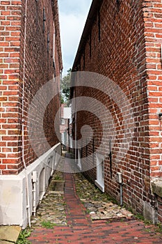 Narrow corridor between two houses made of clicker bricks