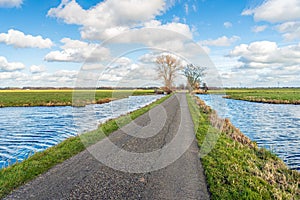 Narrow country road in a Dutch polder with ditches