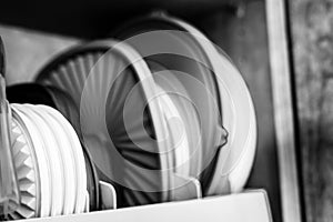 Narrow depth of field picture of an open kitchen cabinet with rows of organized storage of plastic lids.