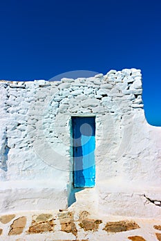 Narrow door in ancient whitewashed wall