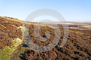 Narrow footpath crosses a hillside over the Derbyshire moorand