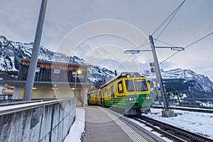 Narrow gauge cog train is stopped at Wengen train station high a