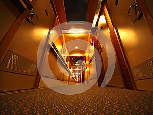 Narrow illuminated corridor in cruise ship