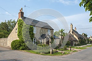 Narrow lane with romantic thatched houses and stone cottages in the lovely Minster Lovell village, Cotswolds, Oxfordshire