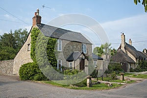 Narrow lane with romantic thatched houses and stone cottages in the lovely Minster Lovell village, Cotswolds, Oxfordshire