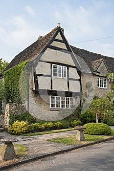 Narrow lane with romantic thatched houses and stone cottages in the lovely Minster Lovell village, Cotswolds, Oxfordshire