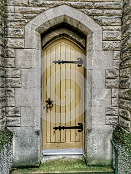 Narrow light coloured door with cast iron hinges